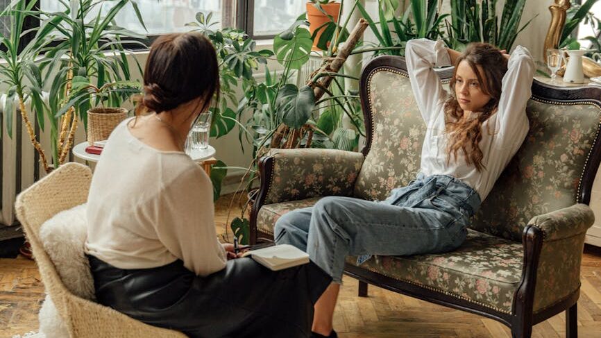 woman in white long sleeve shirt sitting on brown armchair